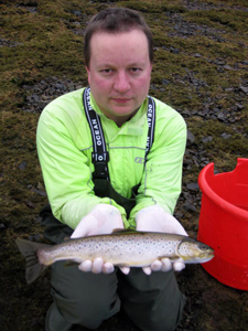 Freshwater biologist, Jonah Tosney, with a sea trout from the River Carron